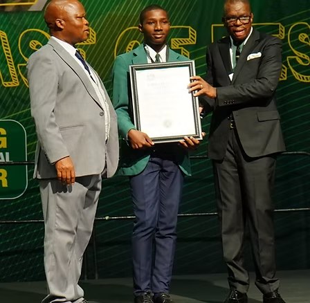Learner holding a trophy and certificate